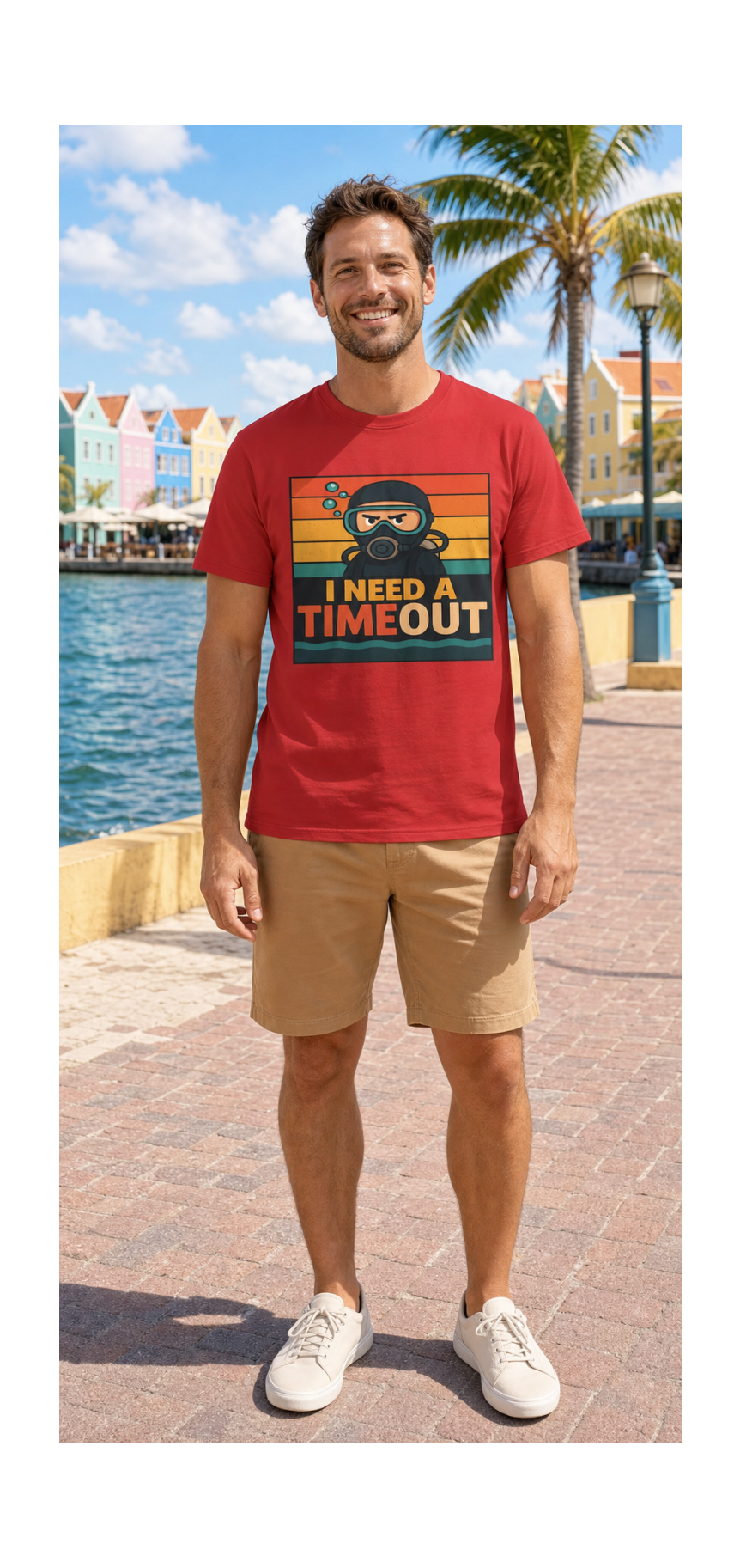 A man wearing a red graphic t-shirt with a retro design that reads 'I NEED A TIMEOUT' and a cartoon character, paired with khaki shorts and white sneakers, standing on a sunny waterfront promenade.